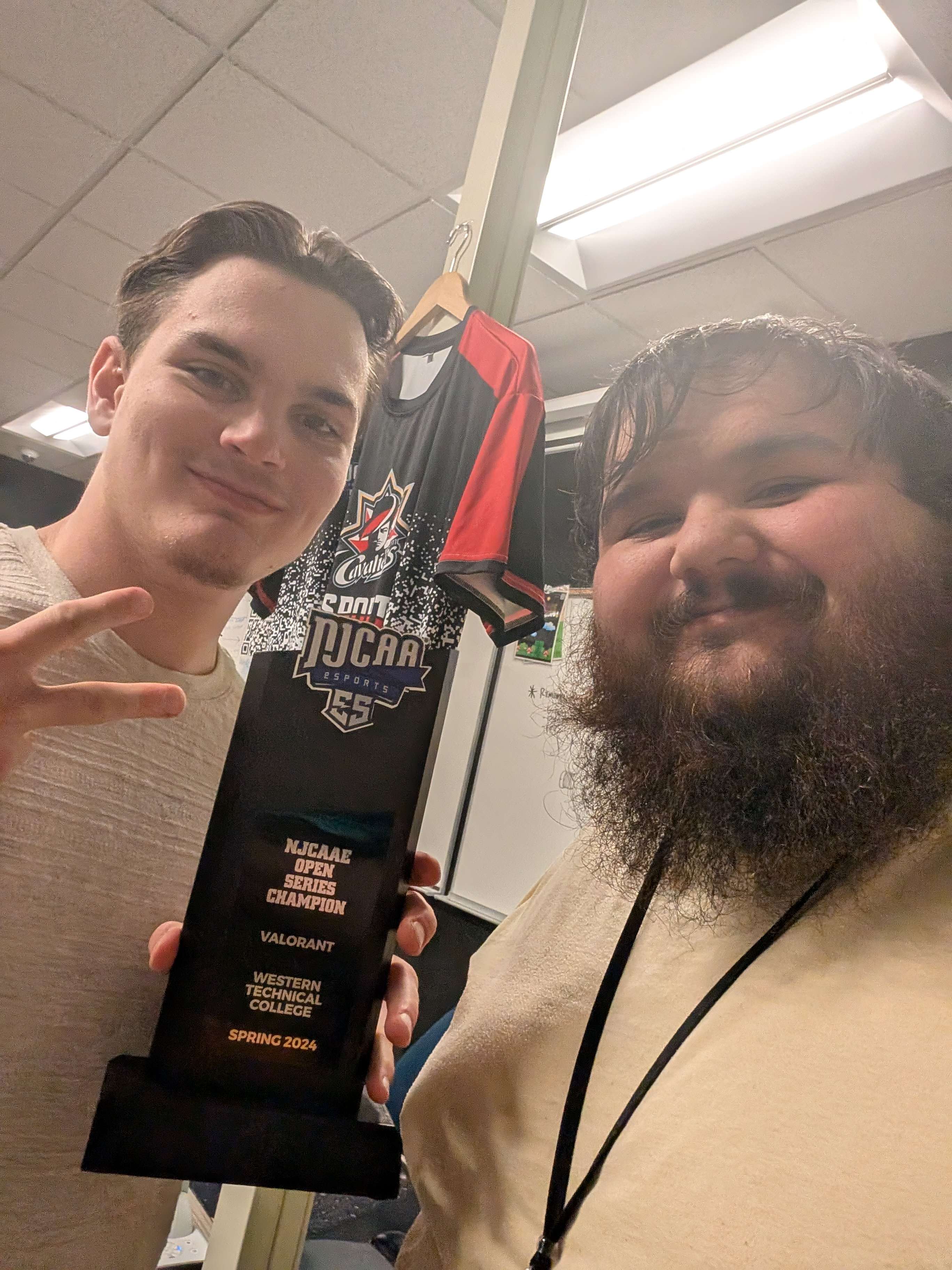 My teammate and I holding our esports trophy